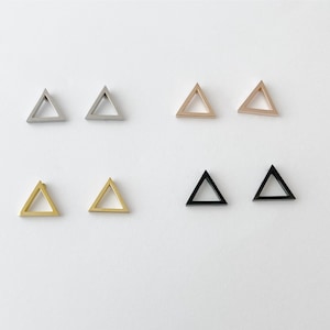 May include: Six pairs of triangle-shaped earrings in silver, gold, rose gold, and black.