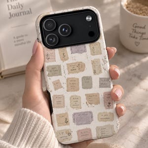 May include: A smartphone case featuring a cream-colored background with a repeating pattern of vintage-style postage stamps and labels in muted shades of lavender, beige, and brown, accented with small botanical line drawings and French text.