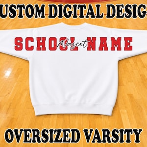 May include: A white long-sleeve sweatshirt featuring the red text SCHOOL NAME in a block font and the word Mascot in a black script font across the chest. The top text reads CUSTOM DIGITAL DESIGN and the bottom text reads OVERSIZED VARSITY.
