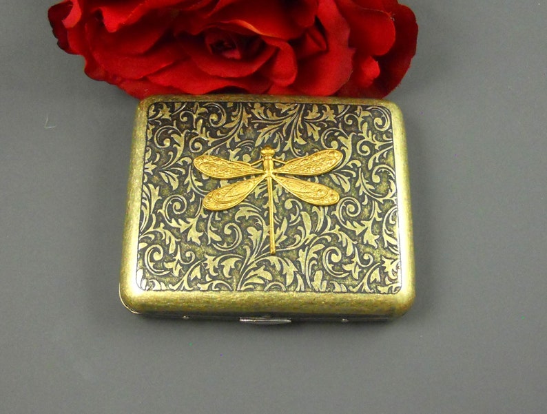 20 Pcs Regular Size cigarettes tobacco holder pocket box storage.   Decorated with brass dragonfly to give it a vintage appearance.  It can fit in your pocket easily.  
The box is 9.5 cm (3.74 inches) long and 8 cm (3.14 inches) wide.