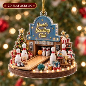 May include: A 2D flat acrylic Christmas ornament shaped like a bowling alley with the text David's Bowling Club. It features a bowling lane, pins, a ball, a teddy bear, a decorated Christmas tree, gifts, and a snowman on a wooden base.