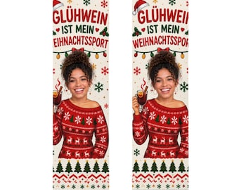Op de afbeelding: Een paar sokken met een crèmekleurige achtergrond en een rood-groen kerstpatroon. Het ontwerp bevat de tekst GLÜHWEIN IST MEIN WEIHNACHTSSPORT, sneeuwvlokken en een fotoprint van een persoon die een rode trui met patroon draagt.
