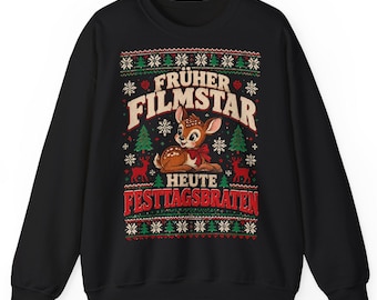 Op de afbeelding: Een zwart sweatshirt met lange mouwen en een grafische print van een reekalf met een rode strik. De tekst "FRÜHER FILMSTAR HEUTE FESTTAGSBRATEN" wordt omringd door een patroon van groene dennenbomen, rode rendieren en witte sneeuwvlokken.