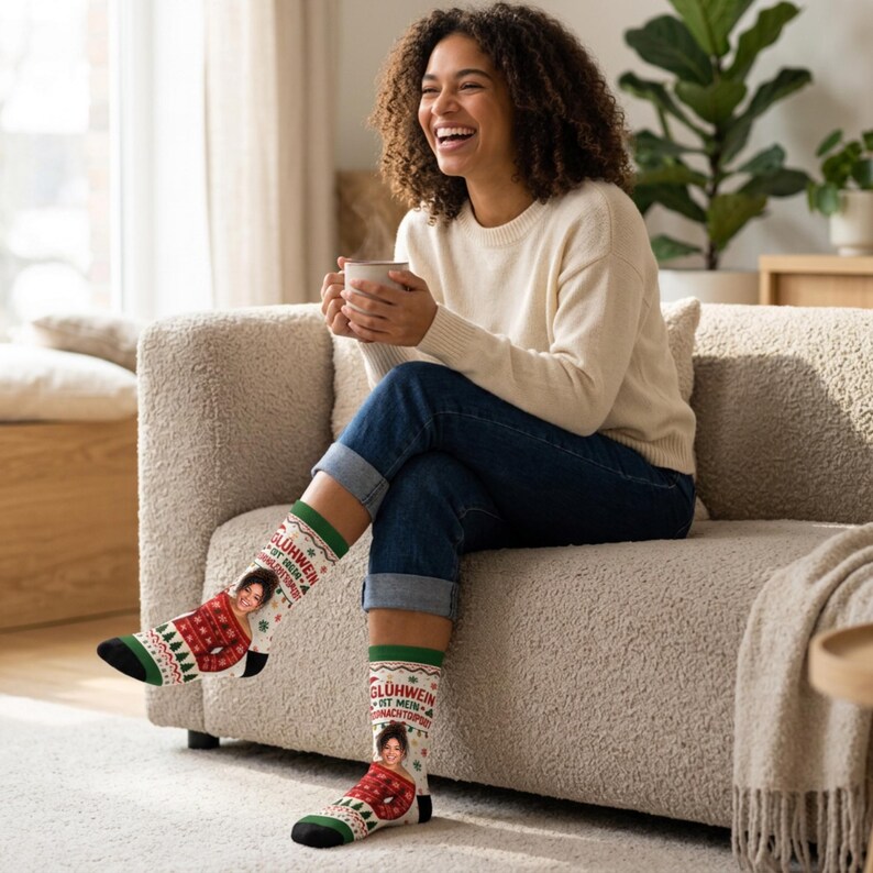 May include: A pair of white crew socks featuring a festive red and green pattern with small Christmas trees and snowflakes. The socks display a custom photo of a person wearing a red sweater and the German text Gl&uuml;hwein ist mein Weihnachtspullover.