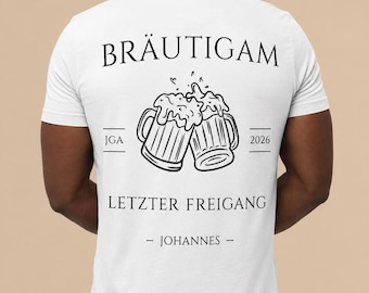 May include: A white short-sleeved t-shirt featuring a black graphic of two clinking beer mugs. The text reads BRÄUTIGAM, JGA 2026, LETZTER FREIGANG, and - JOHANNES - in a serif font. The design is centered on the back of the garment.