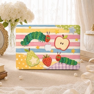 May include: A laptop hard shell case featuring a colorful illustration of a green caterpillar, a red apple slice, a green pear, and a red strawberry on a background of horizontal yellow, pink, and blue stripes with small yellow stars.
