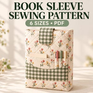 May include: A quilted book sleeve sewing pattern featuring a cream fabric with a small floral print and a green and white gingham check flap and pocket. The text reads BOOK SLEEVE SEWING PATTERN 6 SIZES PDF. Three pens are in the pocket.