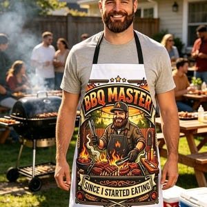 Pode incluir: Um avental branco com um gráfico colorido de uma pessoa barbuda a grelhar carne. O texto diz BBQ MASTER no topo e SINCE I STARTED EATING na parte inferior. A ilustração inclui chamas, um grelhador e utensílios de cozinha em tons quentes.