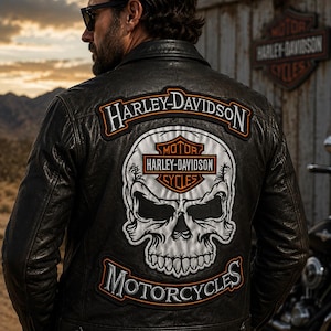 May include: A black leather jacket featuring a large embroidered patch on the back. The patch displays a white skull graphic with the Harley-Davidson Motor Cycles logo above it, and the text Harley-Davidson Motorcycles arched around the skull.