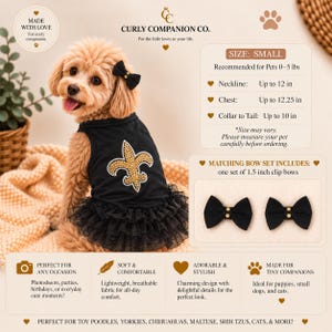 Op de afbeelding: Een kleine zwarte huisdierenjurk met een gouden strass fleur-de-lis embleem en een zwarte tule ruche rok. De set bevat twee zwarte clip-strikjes van 3,8 cm. De jurk heeft een klein zwart strikje bij de kraag, voor huisdieren tot 2,3 kg.