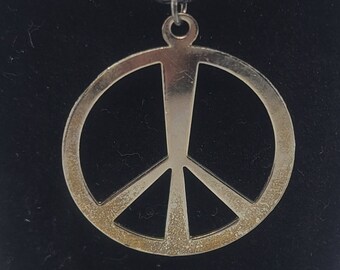 May include: A silver peace sign pendant necklace on a black leather cord.