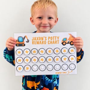May include: A rectangular reward chart with a white background featuring orange construction vehicle illustrations and the text JAXON'S POTTY REWARD CHART. It includes three rows of circular spots, some filled with yellow star stickers and others blank.
