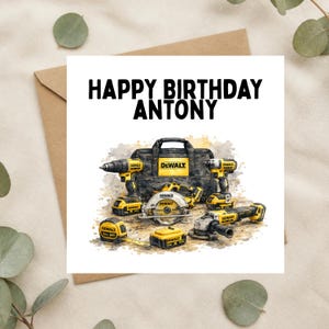 May include: A square greeting card featuring the text HAPPY BIRTHDAY ANTONY in black capital letters above a watercolour illustration of yellow and black DeWalt power tools, including a drill, circular saw, angle grinder, and tape measure.