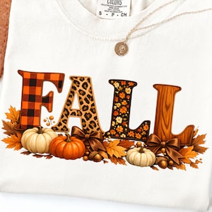Peut inclure: Un t-shirt blanc avec le mot FALL écrit en grandes lettres aux motifs variés, incluant un carreau orange et noir, un imprimé léopard, des fleurs et un effet bois. Le design présente des citrouilles, des nœuds marron et des feuilles d'automne.