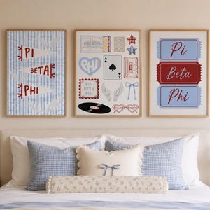 May include: Three framed wall art prints featuring Pi Beta Phi sorority themes. The left print shows blue striped pennants with red text. The center print displays various icons like a heart, playing card, cassette, and record. The right print features three ticket-shaped labels with the text Pi Beta Phi.