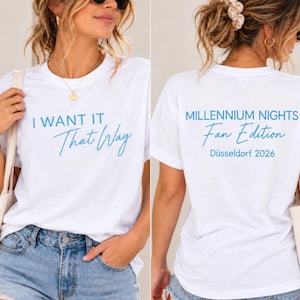 May include: A white short-sleeve t-shirt featuring blue text. The front displays the words "I WANT IT That Way" in a mix of block and script fonts. The back features the text "MILLENNIUM NIGHTS Fan Edition" and "Düsseldorf 2026" in blue.