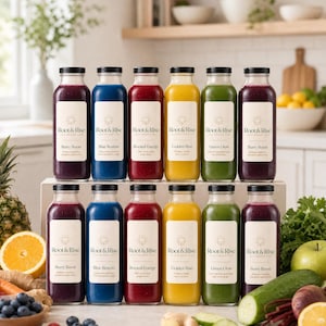 Puede incluir: Doce botellas de vidrio de zumo prensado en frío Root & Rise dispuestas en dos filas. Las botellas contienen zumos de colores en tonos morado, azul, rojo, amarillo y verde. Cada botella lleva una etiqueta blanca con la marca y el sabor.