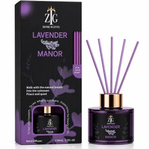 May include: A 50ml Lavender Manor reed diffuser set featuring a black box with purple floral graphics and text, including the phrase 'Heal your heart'. The set includes a purple glass bottle with a gold collar and five purple reed sticks.