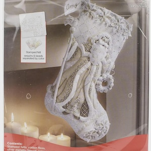 May include: A Bucilla Elegant Christmas felt stocking kit in a plastic package. The 18 inch stocking features a white and cream Santa Claus design with sequins, beads, and metallic thread. The kit includes stamped felt, cotton floss, and needles.