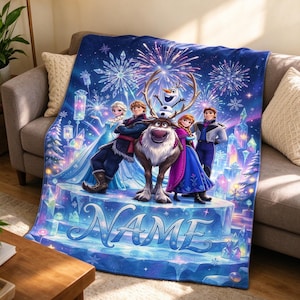 May include: A blue fleece throw blanket featuring a printed graphic of Elsa, Kristoff, Sven, Olaf, and Anna from Frozen. The design includes fireworks, snowflakes, and ice crystals in the background. The word NAME is printed in large blue script.