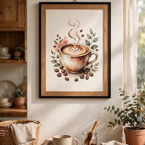 Può includere: Una stampa artistica da parete incorniciata raffigurante un'illustrazione ad acquerello di una tazza da caffè in ceramica con latte art, circondata da vapore, foglie verdi e chicchi di caffè tostati su uno sfondo color crema.