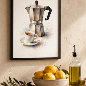 Può includere: Una stampa ad acquerello incorniciata raffigurante una moka argentata e una tazzina da espresso bianca su piattino. L'opera è inserita in una sottile cornice nera e mostra un'illustrazione dettagliata di una caffettiera con schizzi.