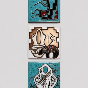 May include: Three square ceramic tiles featuring hand-painted designs. The top tile shows a black flute player on a turquoise background. The middle tile depicts a tan pottery vessel and a black animal figure. The bottom tile displays a figure with wings.