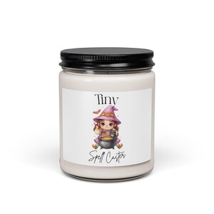 Peut inclure: Une bougie en pot de verre transparent avec un couvercle noir contenant de la cire blanc cassé. L'étiquette présente une illustration de dessin animé d'un enfant portant un chapeau et une robe de sorcière violet, remuant un chaudron noir.