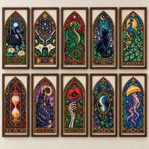 May include: A collection of ten rectangular cross-stitch patterns framed in dark wood, each featuring a stained-glass window design. Subjects include a black swan, moth, dragon, cat, peacock, hourglass, castle, skeleton hand with poppy, moon, and jellyfish.
