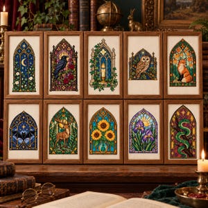 May include: Ten rectangular framed cross-stitch embroideries arranged in two rows. Each piece features a gothic arched window design with colorful motifs including a crescent moon, raven, candle, owl, fox, bat, deer, sunflowers, irises, and a snake.