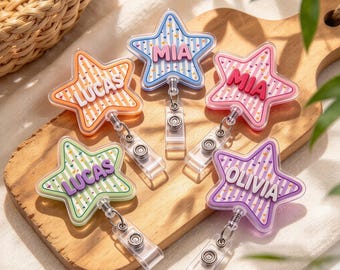 May include: Five star-shaped badge reels with retractable cords and metal clips. Each reel features a striped background with small colorful confetti accents and a raised name tag reading either LUCAS, MIA, or OLIVIA in bold letters.