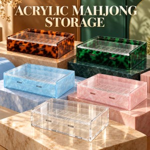 Puede incluir: Cinco cajas rectangulares de acrílico para almacenamiento de mahjong con tapas transparentes y divisores internos. Las cajas presentan varios patrones y colores, incluyendo carey, verde, azul, rosa y transparente, con dos ranuras.