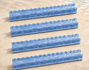 May include: Four long, rectangular blue and white marbled acrylic card holders. Each holder features a scalloped top edge and a horizontal groove designed to support playing cards or similar items in an upright position for easy viewing.