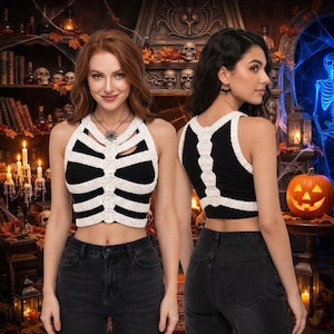 May include: A black sleeveless crop top featuring a white crocheted rib cage design on the front and a white crocheted spine pattern on the back. The garment is paired with dark grey denim jeans, showcasing both the front and back views of the top.