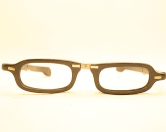May include: Black plastic framed glasses with gold accents on the hinges.