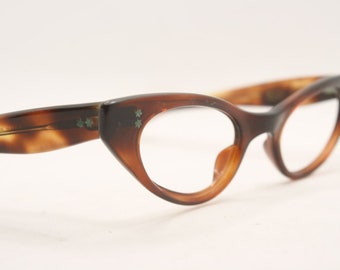 May include: Brown tortoiseshell cat-eye glasses with clear lenses and a star design on the temples.