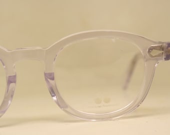 May include: Clear plastic framed glasses with round lenses. The glasses have a subtle purple tint.