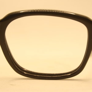 May include: Black plastic rectangular eyeglasses with a thick frame.