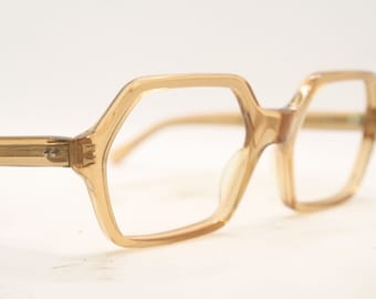 May include: A pair of vintage eyeglasses with a light brown, octagonal frame.