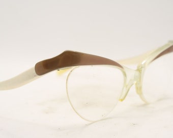 May include: A pair of vintage cat-eye glasses with a white frame and brown accents. The glasses have clear lenses.