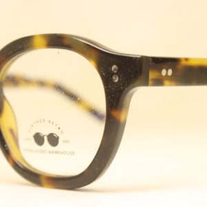 May include: Tortoiseshell eyeglasses with round lenses and a black logo on the right lens that reads "Vintage Retro 3020 Eyewear Warehouse".
