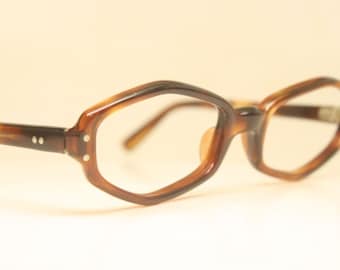 May include: Brown tortoise shell eyeglasses with a geometric frame shape. The glasses have clear lenses.