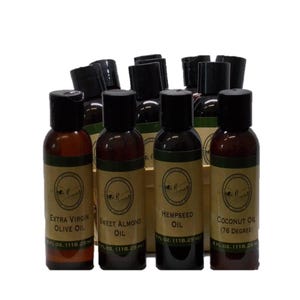 May include: A collection of small amber plastic bottles with black caps, each containing 4 fl. oz. (118.29 ml) of oil. The labels are tan with black text identifying the contents as Extra Virgin Olive Oil, Sweet Almond Oil, Hempseed Oil, and Coconut Oil.
