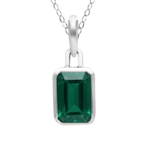 May include: A silver-toned necklace featuring a rectangular emerald-cut green gemstone pendant set in a smooth metal bezel. The pendant hangs from a delicate silver-toned chain with small, uniform links, creating a clean and simple jewelry piece.