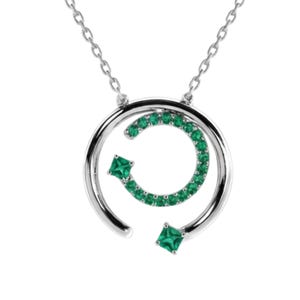 May include: A silver necklace featuring a pendant with two concentric open circles. The inner circle is set with small round green stones and one square green stone. The outer circle is smooth silver with one square green stone at the end.