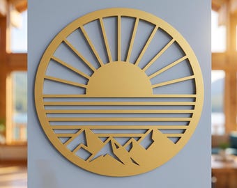 May include: A circular gold-colored wall art piece featuring a cut-out design of a sun rising over a horizon line with horizontal lines representing water and stylized mountain peaks at the bottom, all enclosed within a solid circular frame.