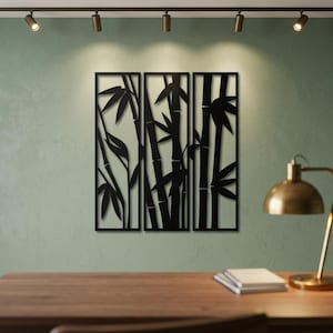 May include: A three-panel black metal wall art set featuring a laser-cut design of bamboo stalks and leaves. The rectangular panels are arranged side-by-side, displaying a continuous silhouette of bamboo plants with segmented stems and pointed foliage.