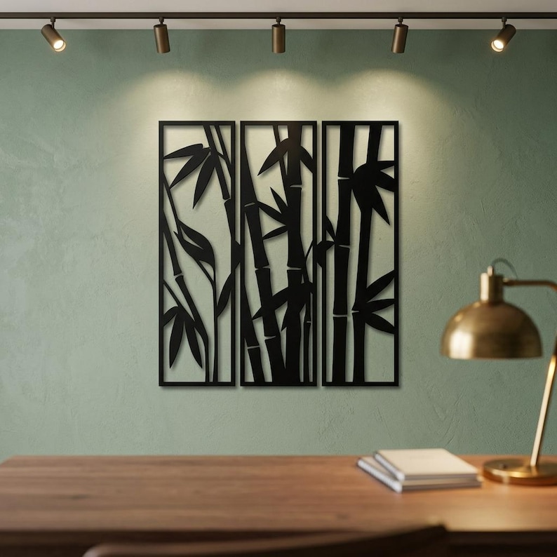 May include: A three-panel black metal wall art set featuring a laser-cut design of bamboo stalks and leaves. The rectangular panels are arranged side-by-side, displaying a continuous silhouette of bamboo plants with segmented stems and pointed foliage.