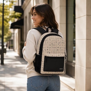 May include: A backpack featuring a cream-colored fabric with a black dashed grid pattern, black trim, black shoulder straps, and a solid black front zippered pocket. The lower right corner of the front pocket displays the text KEEPSKY in small white letters.