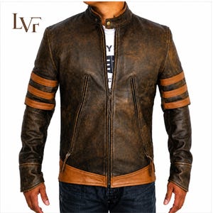 May include: A distressed dark brown leather jacket featuring a stand-up collar with a snap button, a central zipper closure, and two vertical zippered pockets. The sleeves have three horizontal tan leather stripes, and the hem has a tan leather panel.
